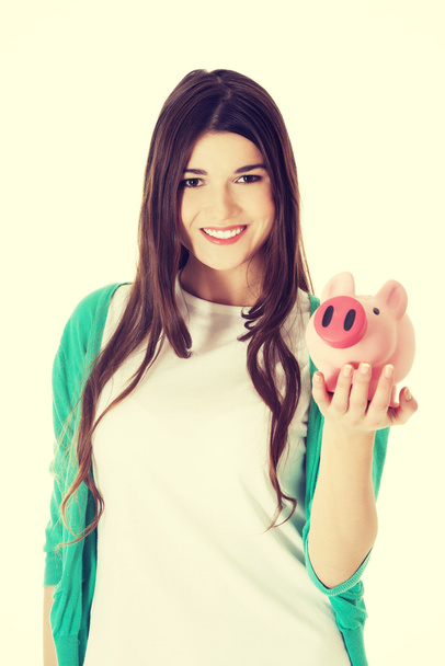 Young casual woman holding piggy-bank. - Foto, Imagem