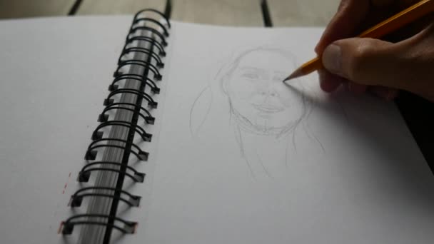 man drawing with pencil on sketchbook - Imágenes, Vídeo