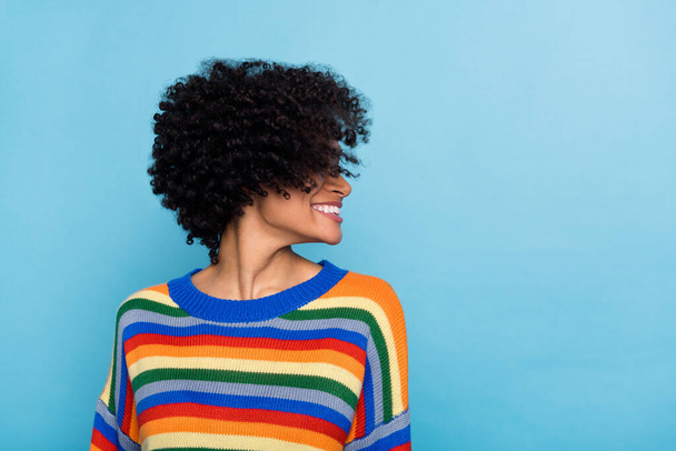 Side photo of cute curly hairstyle lady wear colorful sweater isolated on blue color background. - Φωτογραφία, εικόνα