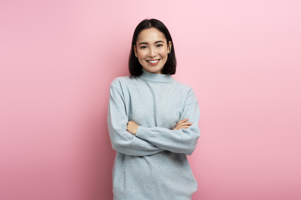 Portrait of pretty smiling happy woman looking at camera with cute positive face, being in good mood. Indoor studio shot isolated on pink background  - Photo, Image