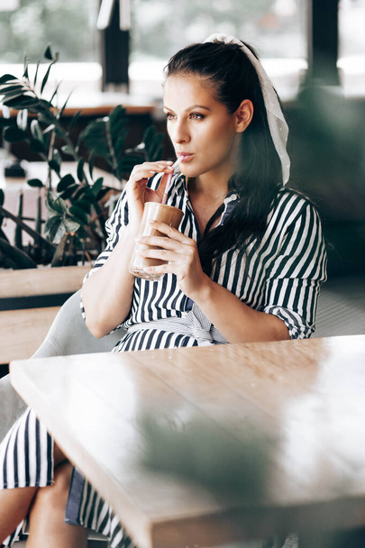 Portrait of a woman in a cafe, drinking coffee - Φωτογραφία, εικόνα