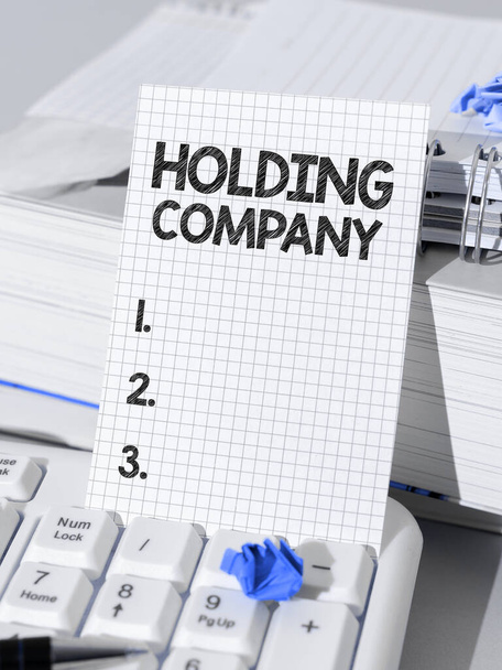 Kirjoittaminen näyttää tekstin Holding Company, liikeidea varastot omaisuutta ja muuta rahoitusomaisuutta jonkun hallussa - Valokuva, kuva