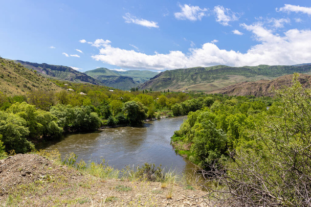 Paesaggio valle del fiume Mtkvari nella regione di Samtskhe Javakheti nella Georgia meridionale con vegetazione lussureggiante e montagne del Caucaso Minore sullo sfondo. - Foto, immagini