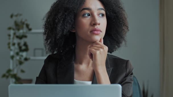 Pensativo joven mujer de negocios mujer afroamericana chica freelancer trabajador mirando el trabajo de la pantalla del ordenador portátil en la oficina pensar nueva idea de negocio comprobar el correo electrónico de compras en línea chat a distancia - Imágenes, Vídeo
