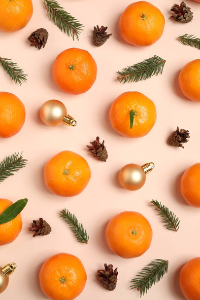 Composition with Christmas balls and tangerines on beige background, flat lay - Foto, afbeelding