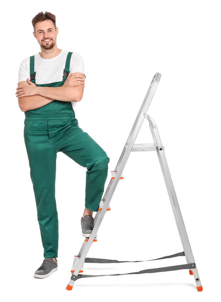 Worker in uniform near metal ladder on white background - Photo, image