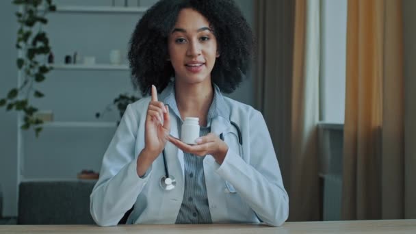 Aantrekkelijke jonge arts vrouwelijke student Afrikaanse vrouw apotheker professionele adviseur houden medische fles met pillen gezonde vitaminen meisje bevorderen apotheek medicatie antibiotica tabletten van allergie - Video