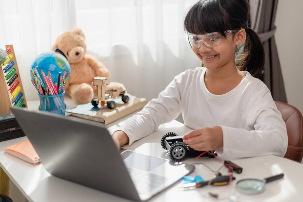 Los estudiantes de Asia aprenden en casa en la codificación de automóviles robóticos y cables de placas electrónicas en STEM, STEAM, matemática ingeniería tecnología código informático en robótica para niños concepto. - Foto, Imagen