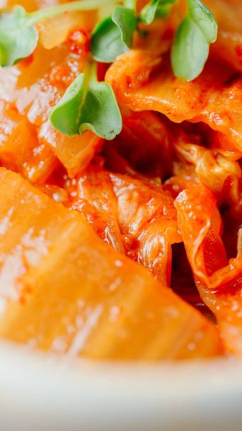 Dobrze sfermentowane kimchi smażone z posiekaną zieloną cebulą i czosnkiem na patelni nasmarowanej olejem, jest to popularne danie boczne zwykle spożywane z ryżem. Pasuje również do fasoli twarogu.. - Zdjęcie, obraz