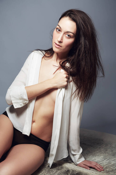 Sensual Seductress. Portrait of a beautiful brunette in her underpants and an open white shirt - Φωτογραφία, εικόνα