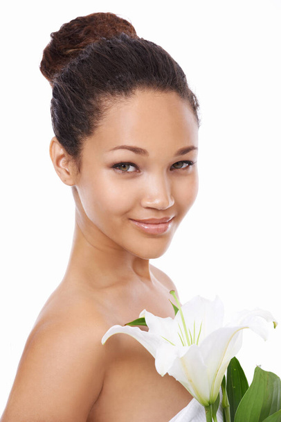 Fresh as a flower. A beautiful young woman holding a lilly against a white background - Photo, Image