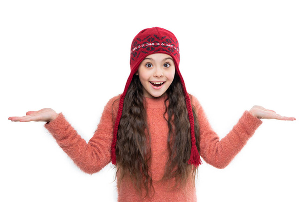 teen girl wear sweater and warm hat presenting product in studio. winter fashion for teen girl. warm hat knitwear. teen girl model in warm hat. teen girl in warm hat isolated on white background. - Foto, imagen