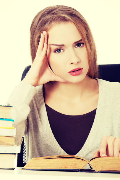 Casual student woman sitting by stack of books. - Φωτογραφία, εικόνα