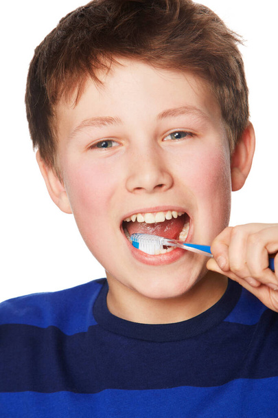 Zapobieganie ubytkom. Portret młodego chłopca myjącego zęby - Zdjęcie, obraz