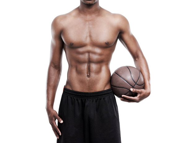 Het lichaam van een professionele sportman. een basketbalspeler zonder shirt in de studio - Foto, afbeelding