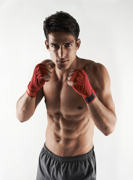 Ready for action. a handsome young kickboxer in the studio - Photo, image