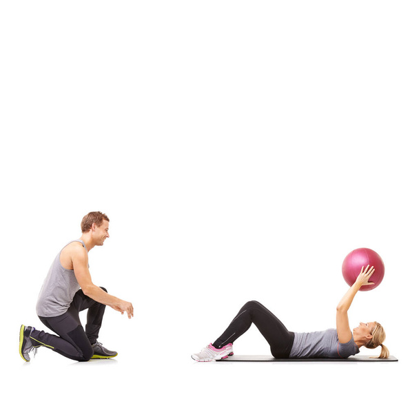 Ejercitando sus abdominales. Un hombre y una mujer ejercitando sus abdominales pasando una pelota de medicina entre sí - Foto, Imagen