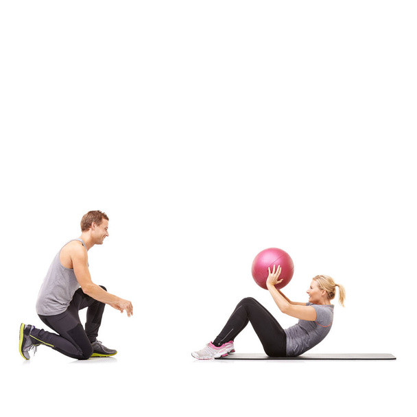 Partners in exercise. A man and woman exercising their abs by passing a medicine ball to each other - Photo, Image
