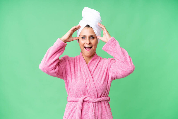 Middle age caucasian woman in a bathrobe over isolated background with surprise expression - Photo, Image