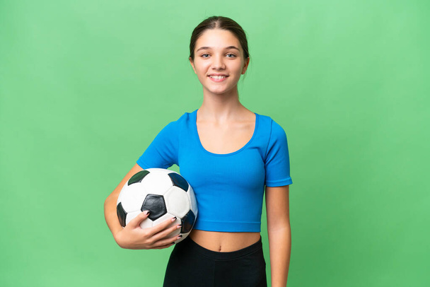 İzole edilmiş arka planda futbol oynayan beyaz bir kız. Çok gülümsüyor. - Fotoğraf, Görsel