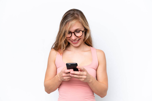 Молода біла жінка ізольована на білому тлі, надсилаючи повідомлення з мобільним
 - Фото, зображення