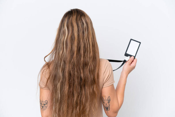 Mulher loira jovem com cartão de identificação isolado no fundo branco na posição traseira - Foto, Imagem