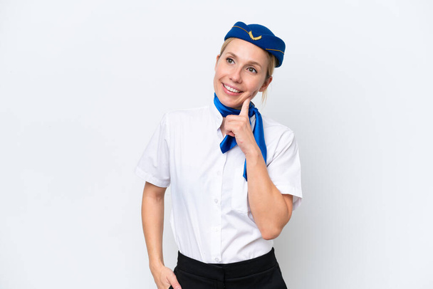 Flugzeug blonde Stewardess Frau isoliert auf weißem Hintergrund denken eine Idee, während Sie nach oben schauen - Foto, Bild