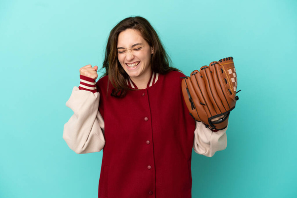 Young caucasian woman playing baseball isolated on blue background celebrating a victory - Foto, Imagem