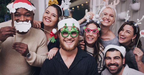 Portret, Kerstmis en vrienden met een man en vrouw groep in een huis voor een feestje of feest samen. Diversiteit, gelukkig en masker met een man en vrouw vriend kroon in huis voor de feestelijke seizoen. - Foto, afbeelding