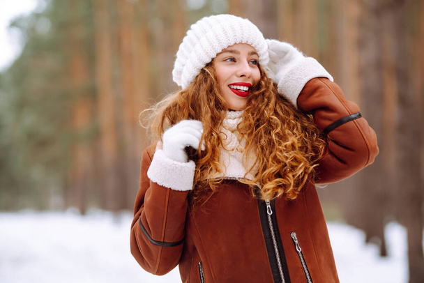 Happy young woman in the winter forest. Christmas, winter holidays concept. - 写真・画像