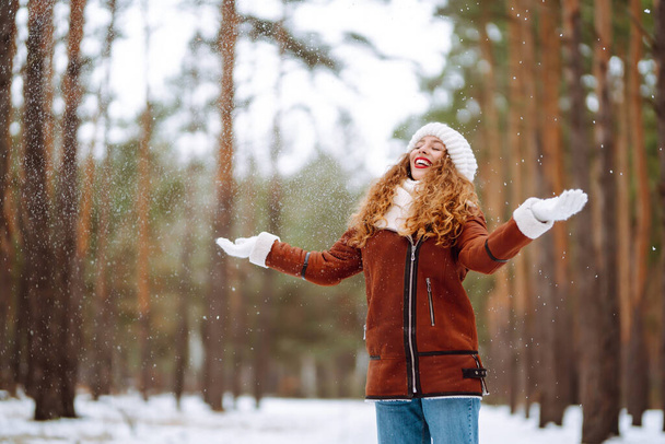 Happy young woman in the winter forest. Christmas, winter holidays concept. - Fotografie, Obrázek
