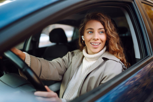 Pretty woman driver smiling to you from the  car. Automobile Journey, traveling, lifestyle concept. Car sharing. - Valokuva, kuva