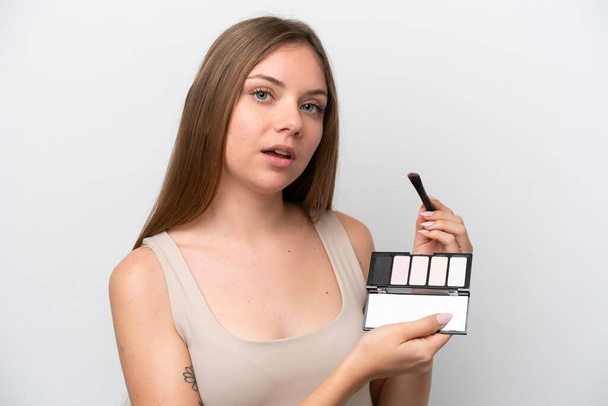Mujer joven lituana aislada sobre fondo blanco con paleta de maquillaje - Foto, Imagen