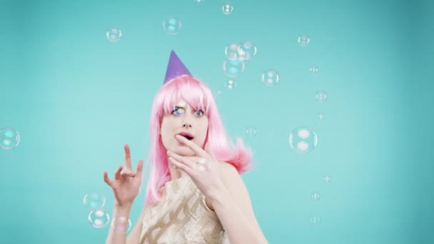 Trippy, party woman and bubbles of a person with crazy, comic and comedy energy with happiness. Photobooth, wig hair and female happy about event and dancing to celebrate birthday with fun smile. - 映像、動画