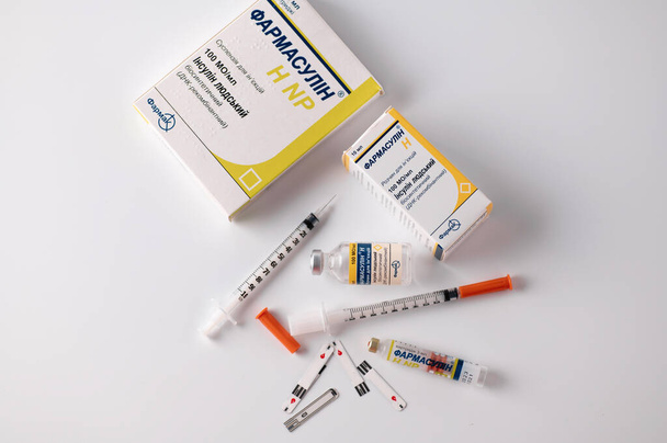 Rivne, Ucraina - 03 luglio 2022 - Insulina umana Farmasulin 100UI / ml, per preparazioni iniettabili a diabetici, controllo dello zucchero nel sangue, siringhe per insulina, fondo bianco - Foto, immagini