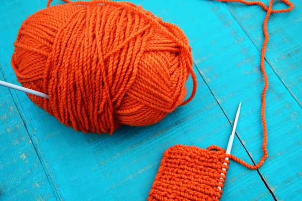 Orange yarn and knitting needles on blue wooden background - Photo, Image