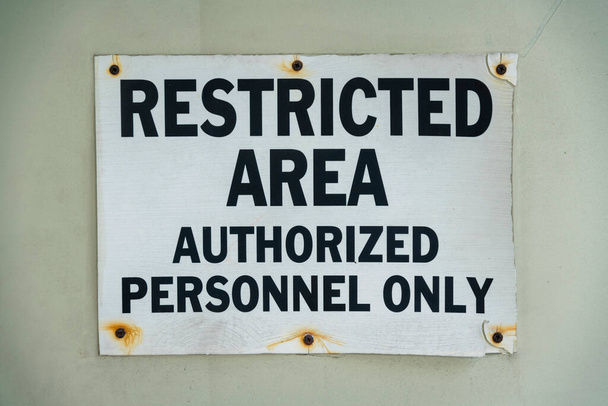 Βιδωμένη σήμανση με σκουριά και περιορισμένη περιοχή εξουσιοδοτημένο προσωπικό μόνο - Μαϊάμι, Φλόριντα. Κοντινό πλάνο πινακίδας σε τοίχο με μαύρα γράμματα. - Φωτογραφία, εικόνα