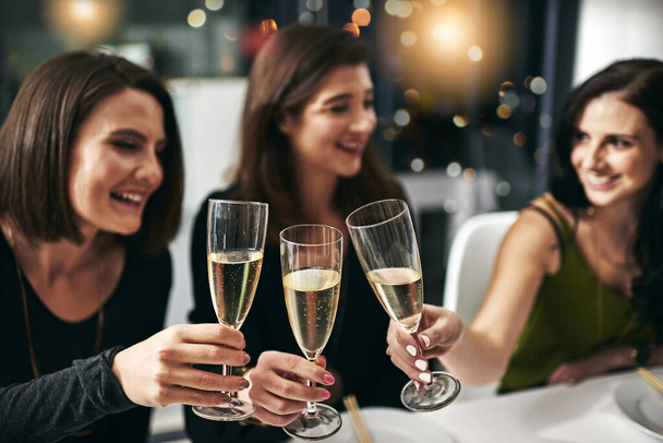 Γιορτή, φίλοι και δείπνο τοστ στο εστιατόριο για την ομαδικότητα, την ευτυχία και την ευεξία με χαμόγελο. Αλκοόλ, φαγητό και ζητωκραυγές γυναικών που πίνουν μαζί για να γιορτάσουν την ευτυχισμένη φιλία - Φωτογραφία, εικόνα