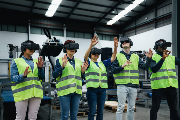 Team di ingegneri con esperienza di simulazione con futuristici occhiali di realtà virtuale all'interno di una fabbrica robotica - Industria tecnologica e concetto metaverso - Foto, immagini