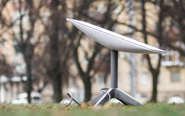 Uzaydan gelen internet sinyalini almak için bir anten. Parktaki yerdeki Starlink. - Fotoğraf, Görsel