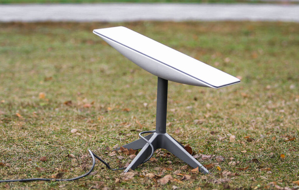 Антена для отримання сигналу Інтернету з космосу Старлінк на землі в парку. - Фото, зображення