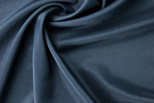 Glatte elegante dunkelblaue Seide für die luxuriöse Stoffstruktur und Hintergrundgestaltung kann als abstraktes Hintergrundkonzept-Design verwendet werden. - Foto, Bild