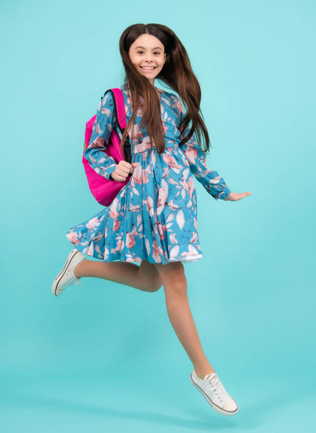 School girl with backpack. Teenager student, isolated background. Learning and knowledge. Go study. Run and jump. Children education concept. Happy teenager, positive and smiling emotions - Photo, Image