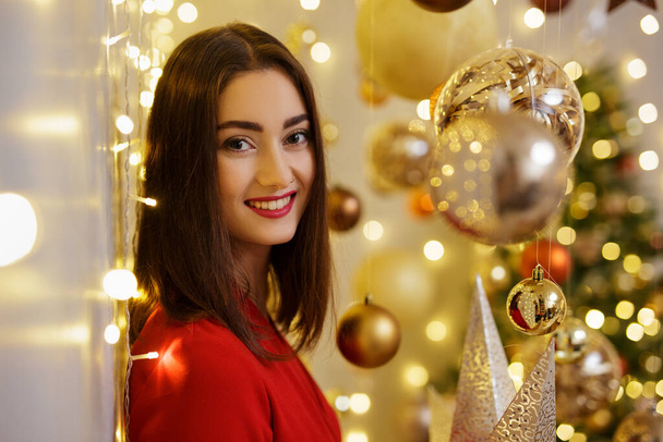 Retrato de mujer feliz en traje rojo en decoraciones de Navidad - Foto, imagen