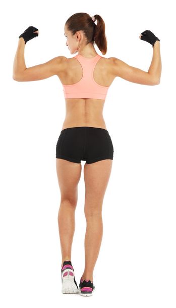 Whole length image of young sporty woman showing her biceps isol - Foto, Imagem