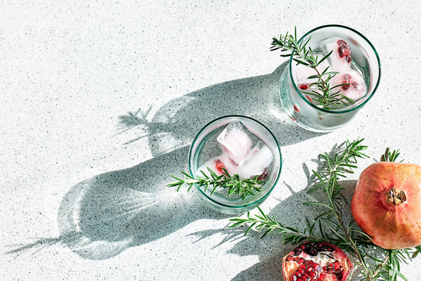 Pomegranate gin fizz cocktail with sparkling wine, rosemary and ice. Holidays refreshing alcoholic drink. Pomegranate cold detox beverage. - Foto, Imagem