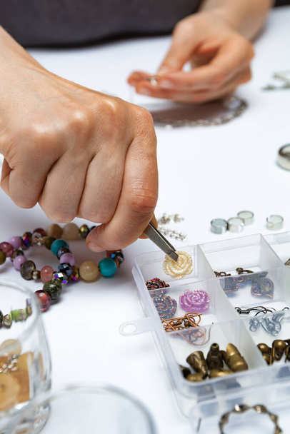 The designer makes handmade jewelry at the workplace. - Photo, Image
