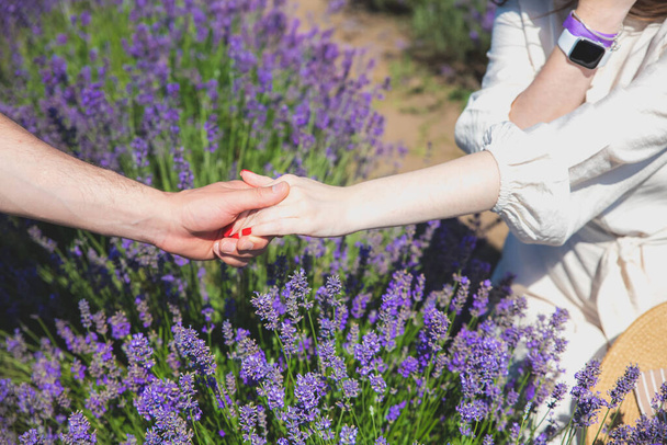 Pár ölelő kéz, romantikus szerelmi történet. Gyönyörű lila levendula virágok a nyári mezőn. Meleg és inspiráló koncepció. Vándorlás és utazás. - Fotó, kép