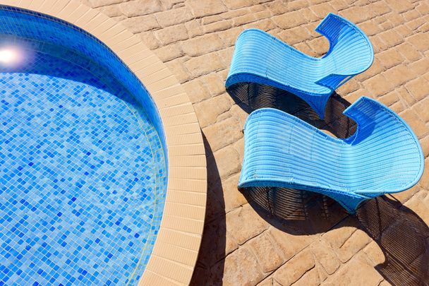 lähikuva uima-altaasta, jossa on aurinkotuoleja
 - Valokuva, kuva