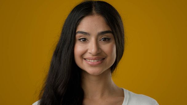 Sarı stüdyo arkaplanlı yakın plan portre 20 'li yaşlarda Hintli etnik kadın kız arkadaş kız model müşteri gülümseme yüz ifadesi kozmetoloji dermatolojisi makyajı - Fotoğraf, Görsel